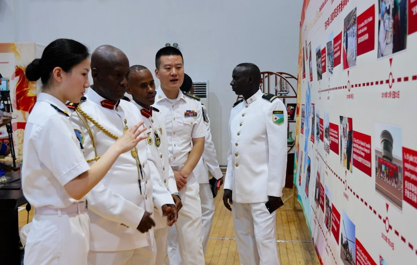 中外官兵在展板前交流。主办方供图