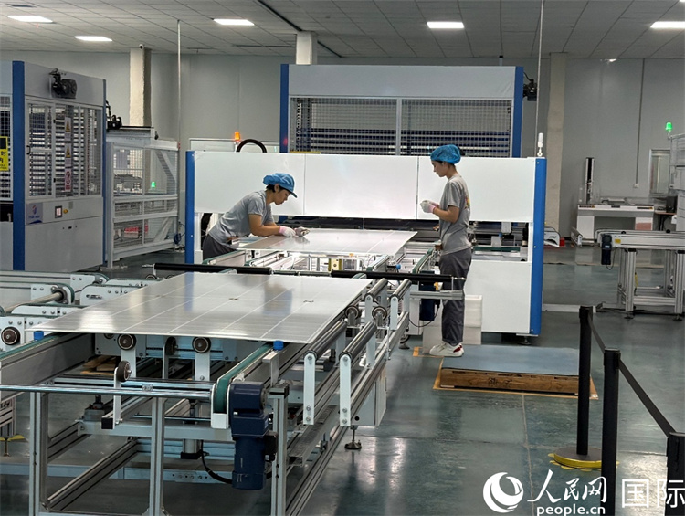 新疆天富天耀新能源科技有限公司工厂内，两名工人正在组装光伏组件。人民网 柯明可摄