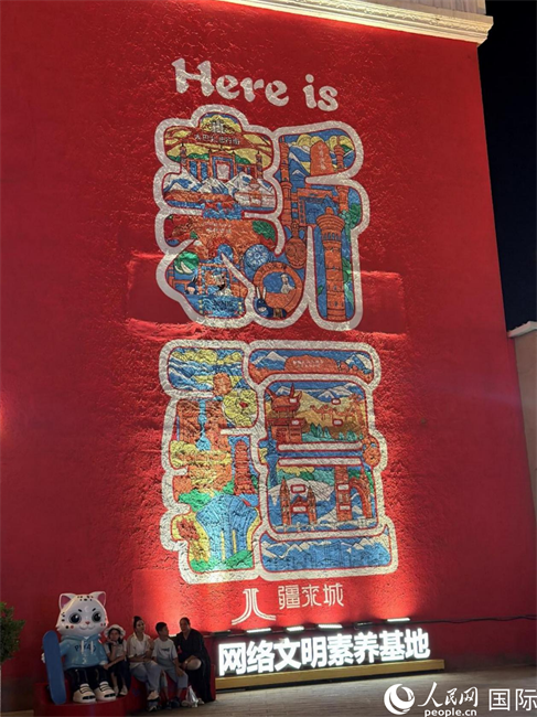 新疆国际大巴扎内，一面巨幅墙绘写着“这里是新疆”。人民网 柯明可摄