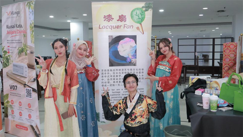 身着中国传统服饰的印尼青年在漆扇体验区合影。印尼阿拉扎大学孔子学院供图