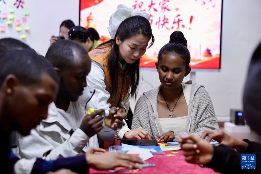 10月1日，在埃塞俄比亚亚的斯亚贝巴大学孔子学院，中方教师宋瑞荣（中）与学生交流。新华社记者 耿馨宁 摄