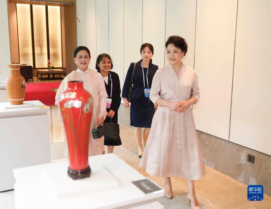 7月27日下午,国家主席习近平夫人彭丽媛在四川成都会见陪同印度尼西亚总统佐科来华出席第31届世界大学生夏季运动会开幕式并访华的总统夫人伊莉亚娜。这是彭丽媛和伊莉亚娜欣赏成都特色非遗工艺品。新华社记者 丁林 摄