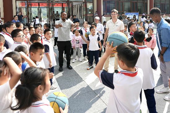 亚尼克与阳城县北留镇皇城村午亭小学的同学们做游戏。人民网 卢鹏宇摄