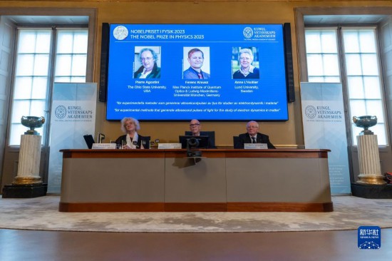 10月3日,在瑞典斯德哥尔摩举行的2023年诺贝尔物理学奖公布现场,屏幕上显示奖项得主皮埃尔·阿戈斯蒂尼(左)、费伦茨·克劳斯(中)和安妮·吕利耶的照片。新华社发(魏学超摄)