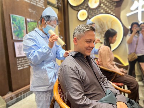 (外媒记者体验艾灸。中国经济周刊记者 郭志强 摄)