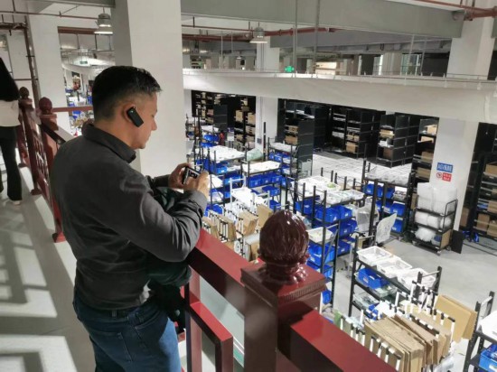 2023“一带一路”媒体合作论坛联合采访团团员在仁和医药物流园拍摄记录转运流程。(本报记者 黄超摄)