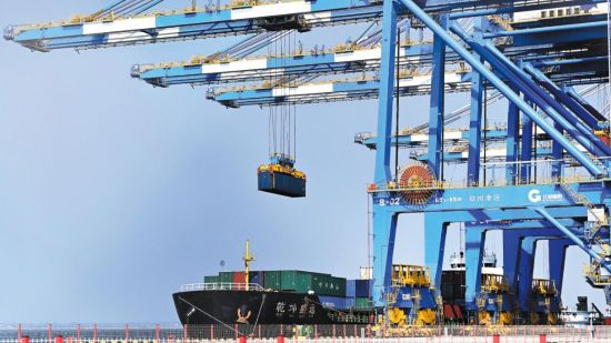 自动化起重机在中国(广西)自由贸易试验区钦州港吊装集装箱。(图片来源:新华社)
