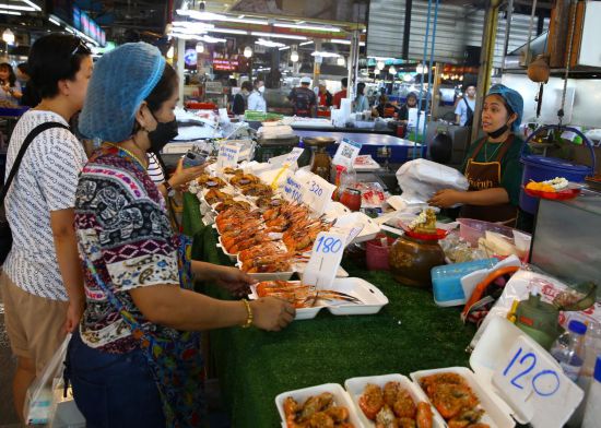 6月22日,人们在位于泰国曼谷的吞武里海鲜市场选购海鲜。新华社记者孙玮彤摄