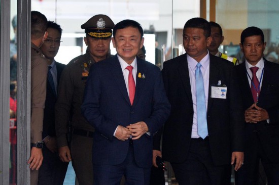 2023年8月22日,泰国前总理他信(中)抵达曼谷廊曼机场。新华社发(拉亨摄)