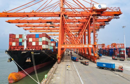 在广西北部湾港钦州港区码头,吊车为货轮卸载集装箱(10月20日摄,无人机照片)。新华社记者李贺摄