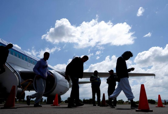 2月14日,在洪都拉斯西北部城市圣佩德罗苏拉的拉蒙·比列达·莫拉莱斯机场,返乡移民走下飞机。新华社发(戴维摄)