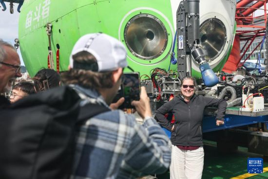 3月21日,在新西兰首都惠灵顿举行的中国-新西兰普伊斯哥海沟载人深潜联合科考总结开放日活动中,参观者在“探索一号”科考船上与“奋斗者”号载人潜水器合影。新华社记者 龙雷 摄