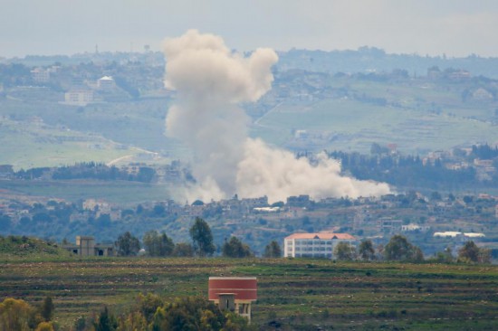 3月22日,在黎巴嫩南部的一处村庄,遭空袭的地点冒起浓烟。新华社发(阿里·哈希绍摄)