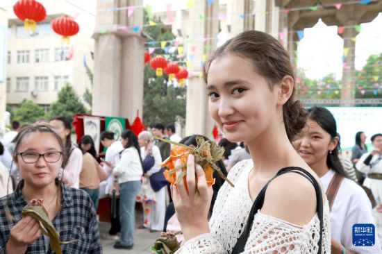 5月30日，在吉尔吉斯斯坦比什凯克，人们在比什凯克国立大学举行的“粽香传情·共庆端阳”端午民俗节上品尝粽子。新华社发（罗曼摄）