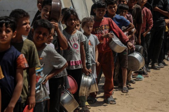 5月28日,孩子们在加沙城西部的沙提难民营等待领取救助食物。新华社发(里泽克·阿卜杜勒贾瓦德摄)