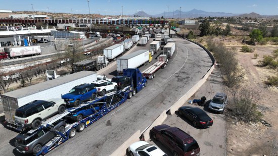 　　4月2日，美国宣布对贸易伙伴征收“对等关税”。图为当天在墨西哥索诺拉州诺加莱斯市，一辆装载多辆汽车的运输车（下中）行驶在墨美边境附近的公路上（无人机拍摄）。新华社记者 李梦馨 摄