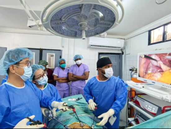 医疗队医生钱益（左一）、韩云（左二）与当地医生拉姆哈里（右一）在手术中（中国医疗队供图）