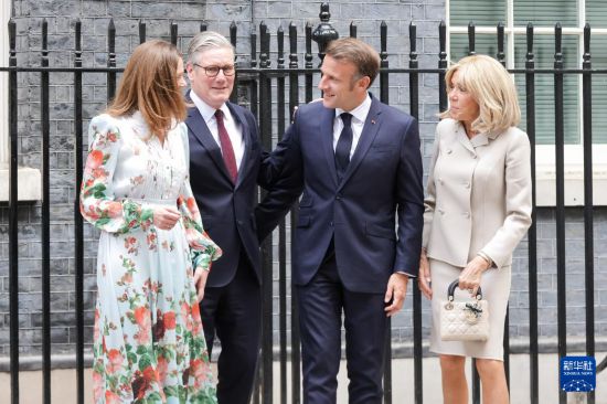 7月9日,英国首相斯塔默(左二)和夫人(左一)在英国伦敦唐宁街10号首相府前迎接法国总统马克龙(右二)和夫人。新华社发