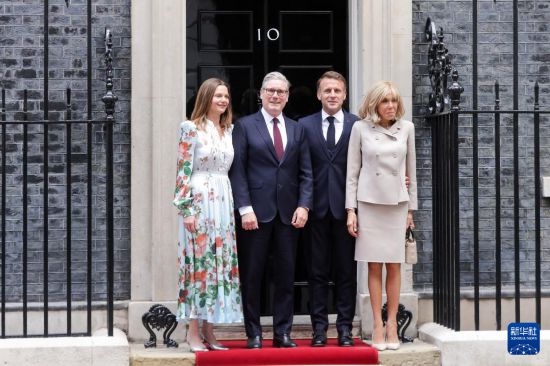 7月9日,英国首相斯塔默(左二)和夫人(左一)在英国伦敦唐宁街10号首相府前迎接法国总统马克龙(右二)和夫人。新华社发