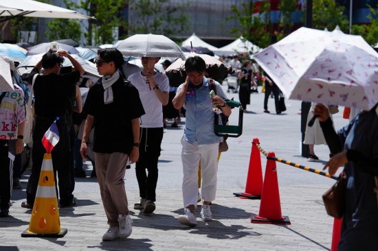 2025年7月10日,游客在日本大阪世博会园区内游览参观。近日,日本多地出现高温天气。日本气象厅和环境省向多地发布“中暑警戒警报”,提醒民众注意防暑。新华社记者 贾浩成 摄