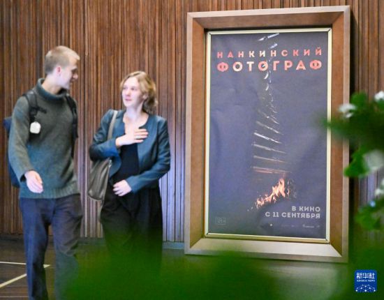 　　9月9日，在俄罗斯莫斯科一家电影院，观众经过电影《南京照相馆》的海报。新华社记者 郝建伟 摄