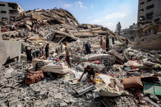 9月15日，人们在加沙城查看遭以军袭击后的废墟。新华社/法新