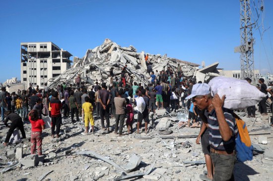 9月8日,人们在加沙城查看一座高层建筑遭以色列军队空袭后的废墟。新华社发(里泽克·阿卜杜勒贾瓦德摄)