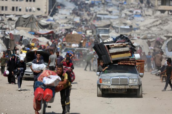 9月18日,在加沙城以西的沿海公路上,人们运载着生活用品,汇入人潮向南撤离。新华社发(里泽克·阿卜杜勒贾瓦德摄)