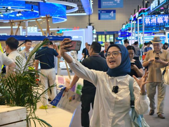 9月25日,在第四届全球数字贸易博览会上,印度尼西亚拉贾瓦里电视台的新闻记者奥利维娅·费拉里为电视台录制视频。新华社记者 刘梓漪 摄