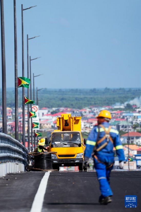 10月2日,在圭亚那首都乔治敦,中国工人在巴拉特·贾格迪奥-德梅拉拉河大桥上作业。新华社记者 许咏政 摄