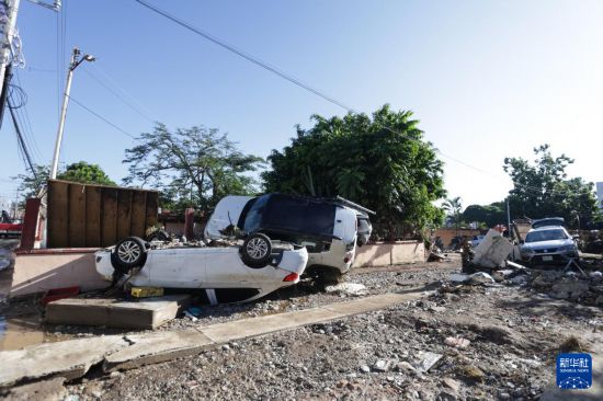 10月12日,在墨西哥韦拉克鲁斯州波萨里卡,被洪水冲毁的车辆叠落在路边。华社发(弗朗西斯科·卡涅多摄)