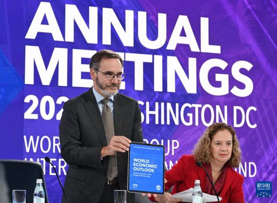 10月14日,在美国华盛顿,国际货币基金组织首席经济学家皮埃尔-奥利维耶·古兰沙(左)在《世界经济展望报告》新闻发布会上展示报告。新华社记者 李睿 摄
