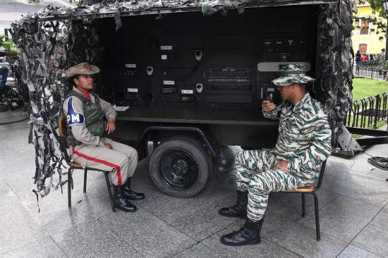10月4日,在委内瑞拉首都加拉加斯的玻利瓦尔广场,玻利瓦尔民兵组织成员操作通信设备。新华社发(马科斯·萨尔加多摄)