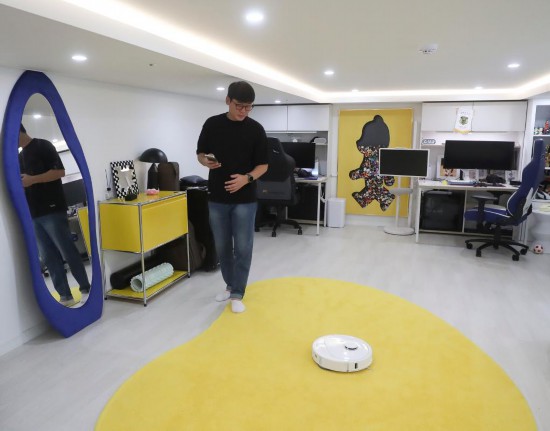 2025年10月13日,韩国消费者在首尔的家中使用扫地机器人。新华社记者姚琪琳摄