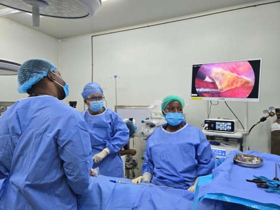 7月23日，在加纳首都阿克拉的中加友好医院，第14批中国援加纳医疗队成员与当地医护人员为患者实施腹腔镜疝修补术。新华社发（第14批中国援加纳医疗队供图）