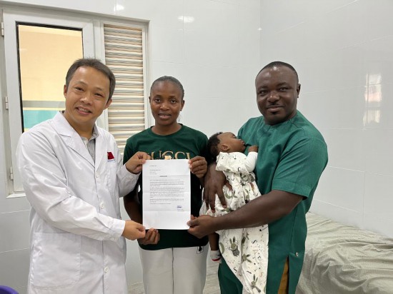 10月21日，胆囊结石患者塞西莉亚（中）及家人为第14批中国援加纳医疗队队长杨永光（左）送上感谢信。新华社发（第14批中国援加纳医疗队供图）