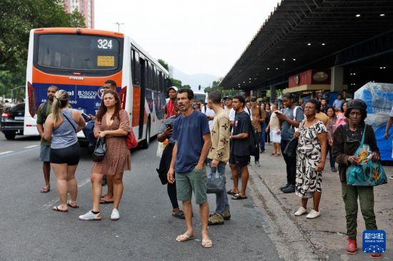 10月28日,巴西警方在里约热内卢展开针对黑帮“红色司令部”的大规模剿匪行动,受公交线路绕行影响,乘客在街边等待。新华社/巴西通讯社