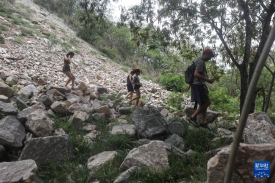 10月29日,在巴西里约热内卢的佩尼亚社区,人们在警方行动后的山坡地区搜索被击毙的犯罪嫌疑人遗体。新华社发(克劳迪娅·马尔提尼摄)