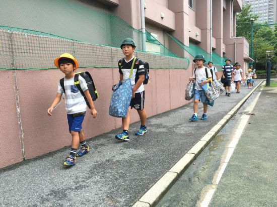 2016年8月30日,在日本东京,学生们背着书包携带各种学习用品走在校园里。新华社记者华义摄