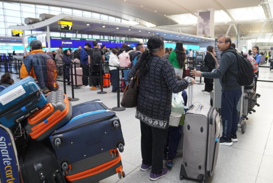 11月5日,在美国纽约肯尼迪国际机场,乘客排队值机。 新华社记者 张凤国 摄