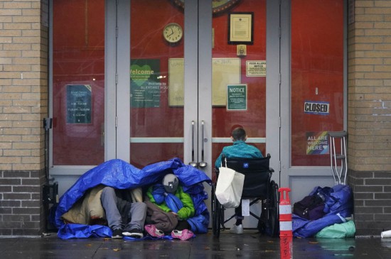 11月5日清晨,在美国波特兰的深秋寒意中,无家可归者蜷缩在街边角落里。 新华社记者 吴晓凌 摄