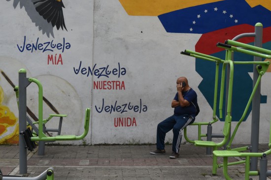 11月5日,在委内瑞拉首都加拉加斯,一名男子坐在号召团结的宣传画前。标语上写着“我的委内瑞拉 我们的委内瑞拉 团结的委内瑞拉”。 新华社发(萨尔加多摄)