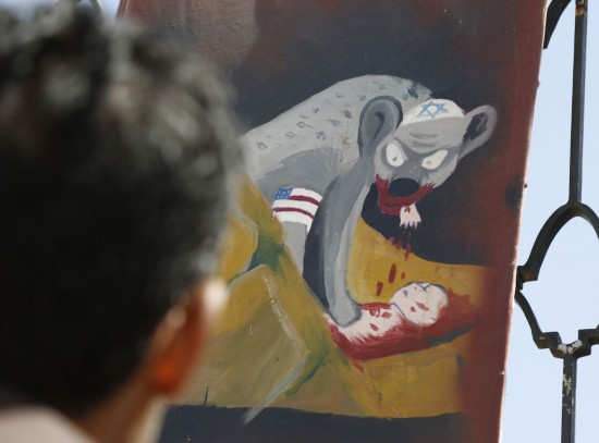 11月5日,一名男子在也门首都萨那街头观看揭露美国以色列暴行的宣传画。 新华社发(默罕默德·默罕默德摄)