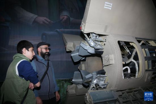 11月12日,民众在伊朗首都德黑兰举办的展览上参观新型导弹。新华社记者 沙达提 摄