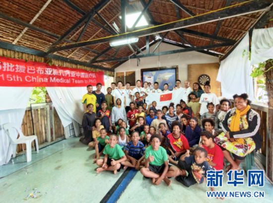 11月17日,第15批援巴布亚新几内亚中国医疗队在巴新首都莫尔兹比港为当地孤儿和贫困儿童提供义诊服务。图为医疗队员与当地儿童、福利机构工作人员合影。(第15批援巴布亚新几内亚中国医疗队供图)