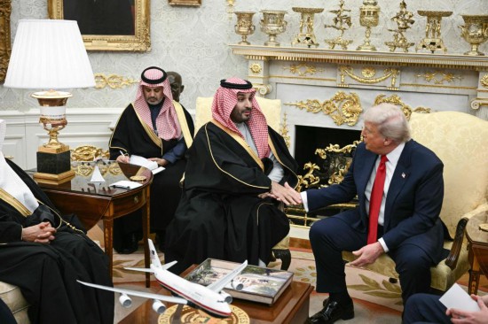 11月18日，美国总统特朗普（右）在华盛顿白宫与到访的沙特阿拉伯王储兼首相穆罕默德（中）握手。新华社/法新