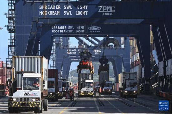 11月18日,在智利圣安东尼奥港,工人们正在进行装卸作业。新华社发(豪尔赫·比列加斯摄)