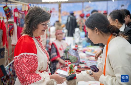 12月20日，一名市民在活动中了解俄罗斯手工艺品。新华社记者 连振 摄