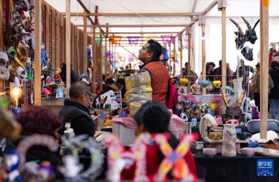 12月30日，在墨西哥首都墨西哥城，人们在手工艺品摊位选购商品。新华社记者 李梦馨 摄