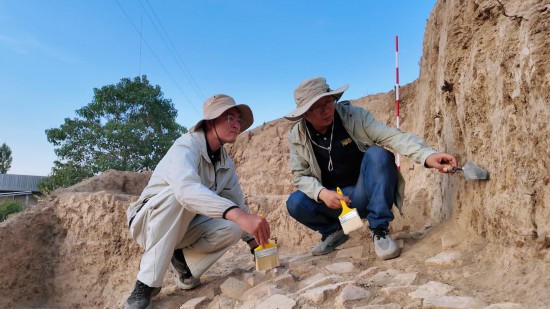 工作人员在乌兹别克斯坦库瓦古城遗址发掘现场工作（2025年6月24日摄）。新华社发